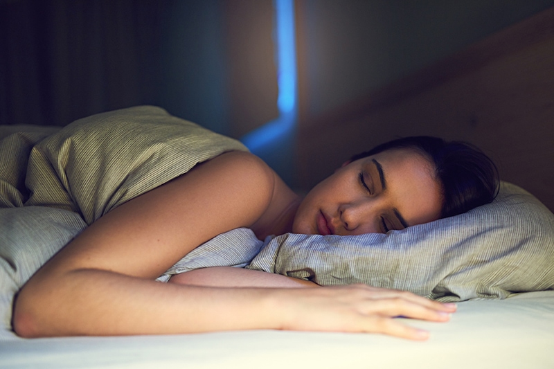 Shot of a young woman sound asleep in her bedroom air conditioning ac sleep benefits